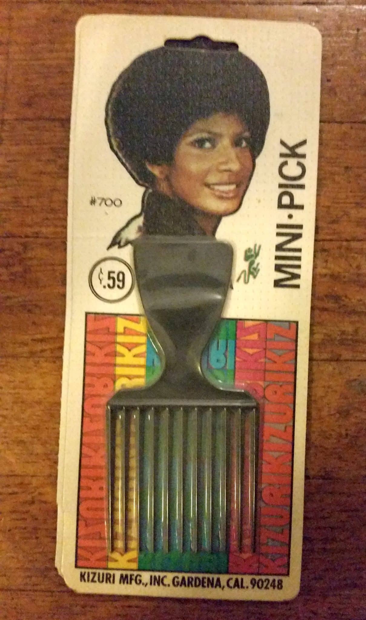 A nit-pick comb in its packaging with a woman smiling on the package