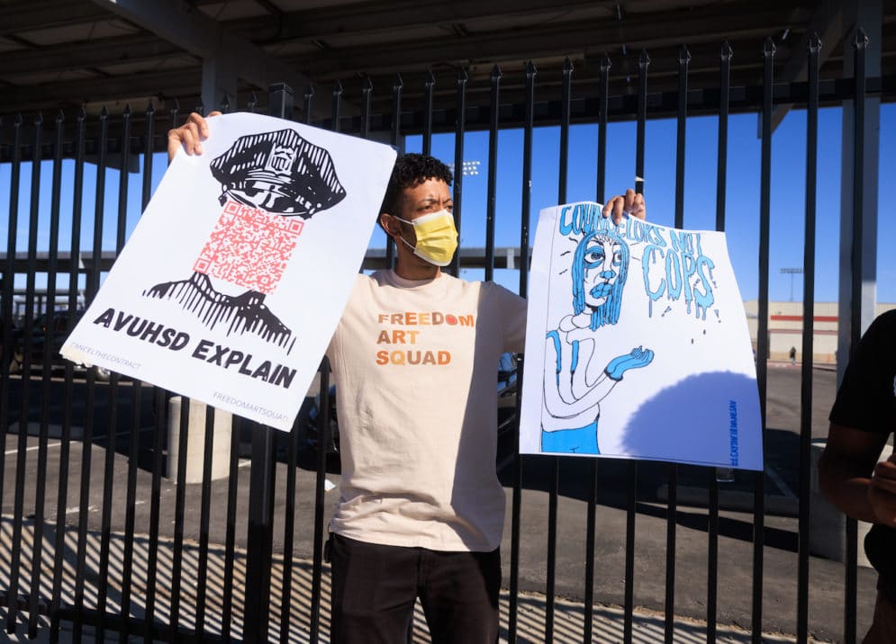 a man in mask carries two protest signs