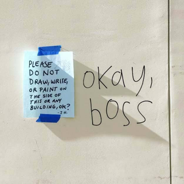 The previous flyer taped to a door, next to large writing 'Okay, boss'