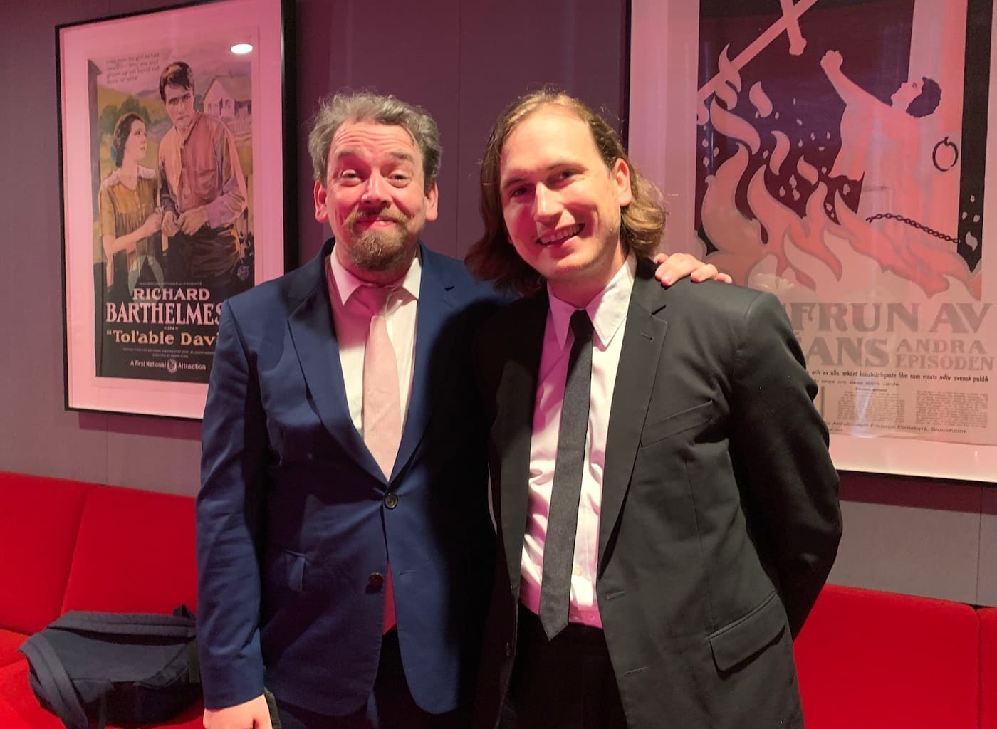 Two men in suits smiling