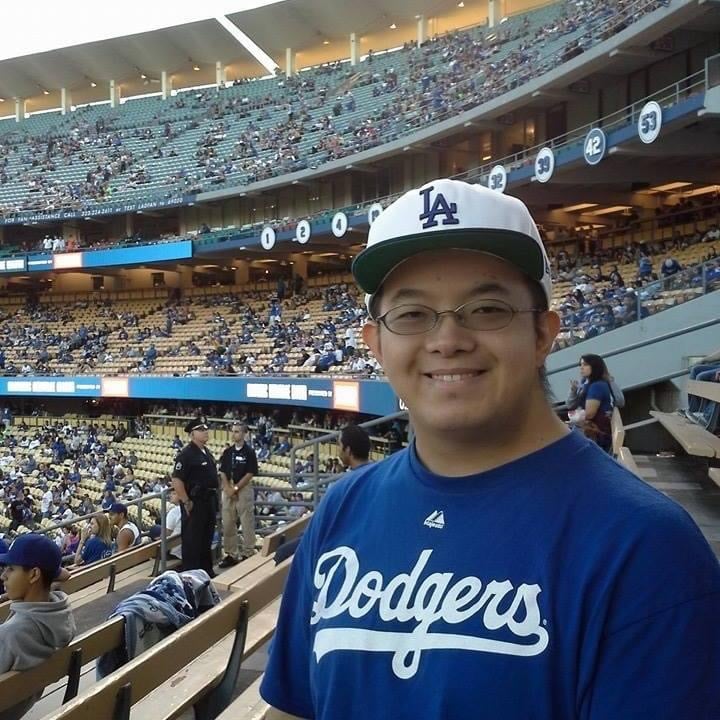 picture of man in a baseball jersey and hat enjoying the Dodgers game
