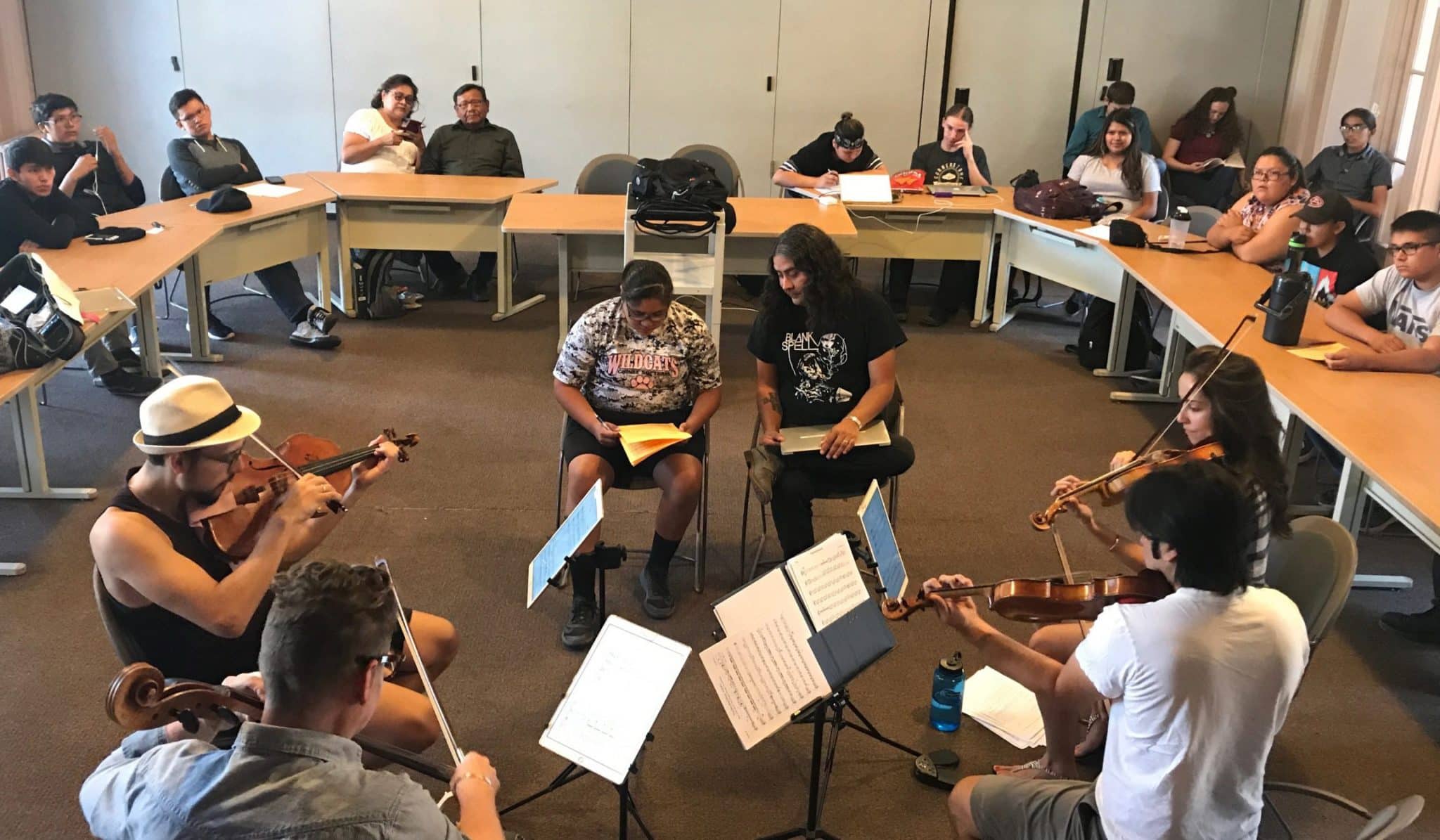 Raven Chacon (right) working with Native American students interested in musical composition. Since 2004, Chacon has served as composer-in-residence for the Native American Composer Apprentice Project (NACAP), mentoring over 300 high school Native composers in the writing of new string quartets. Photo: Clare Hoffman