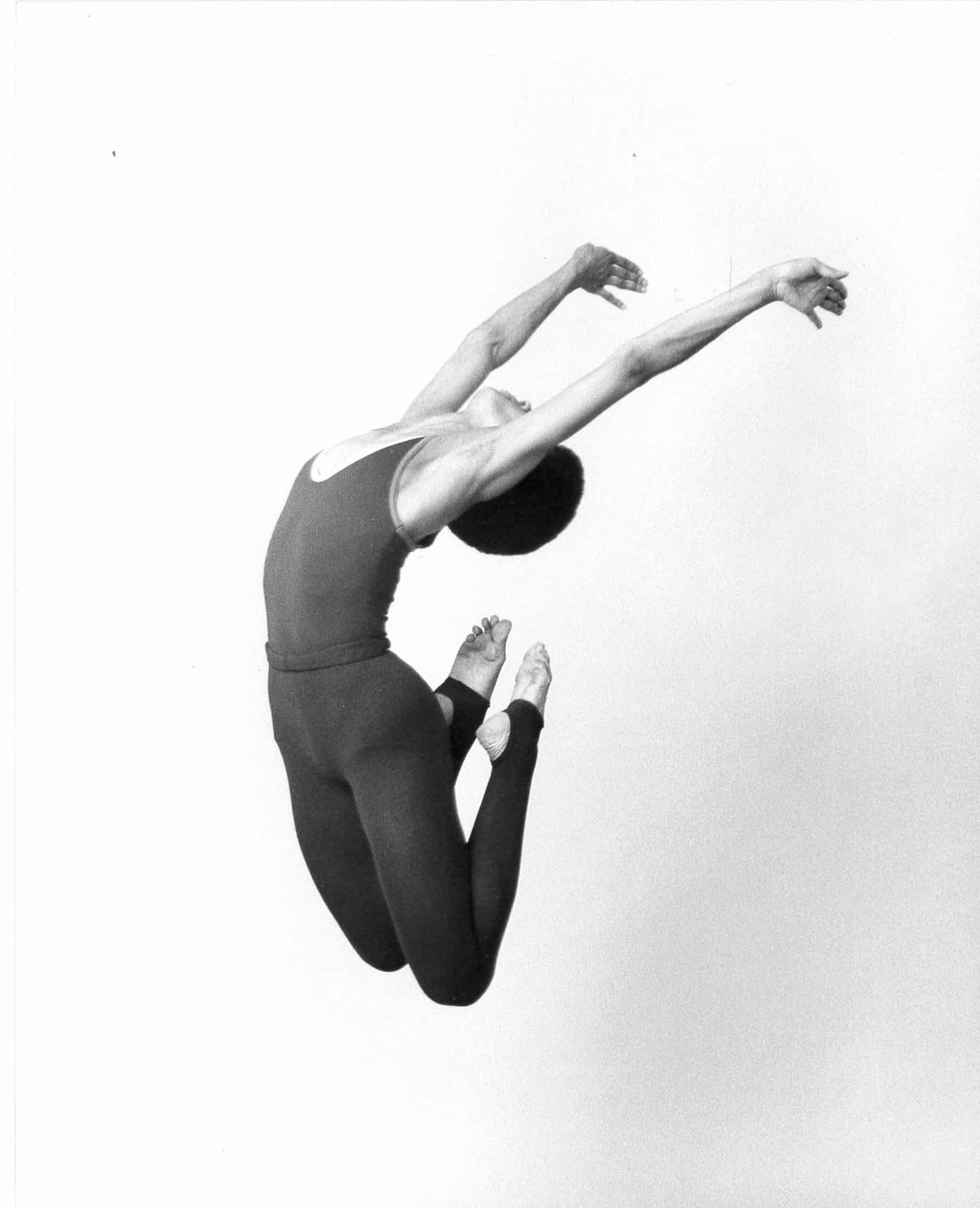 Woman dancing against a white wall