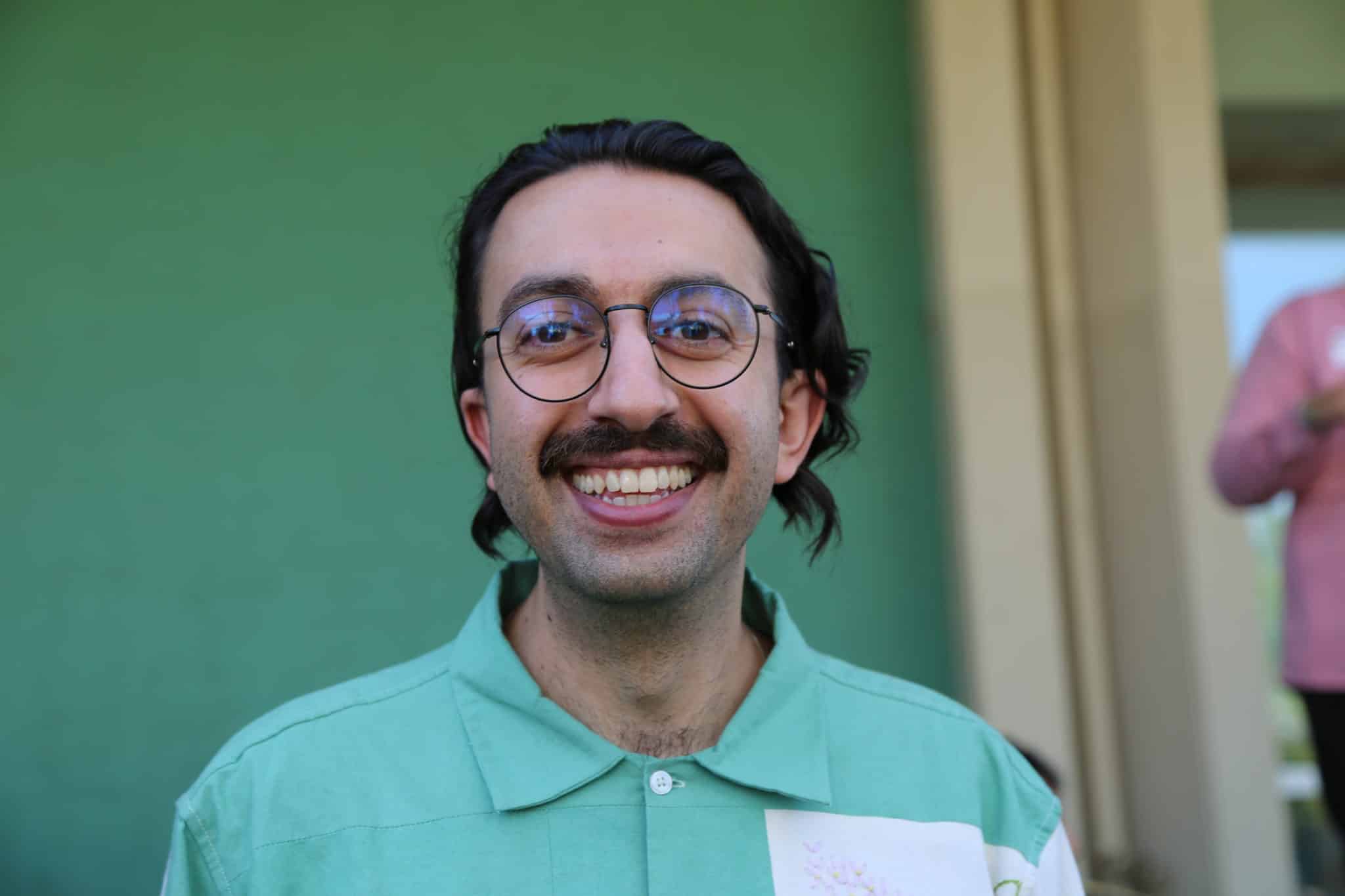 A person in glasses smiles for the camera