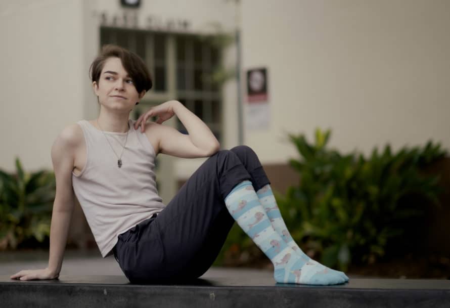 Socks Whitmore poses while seated, wearing narwhal-patterned socks