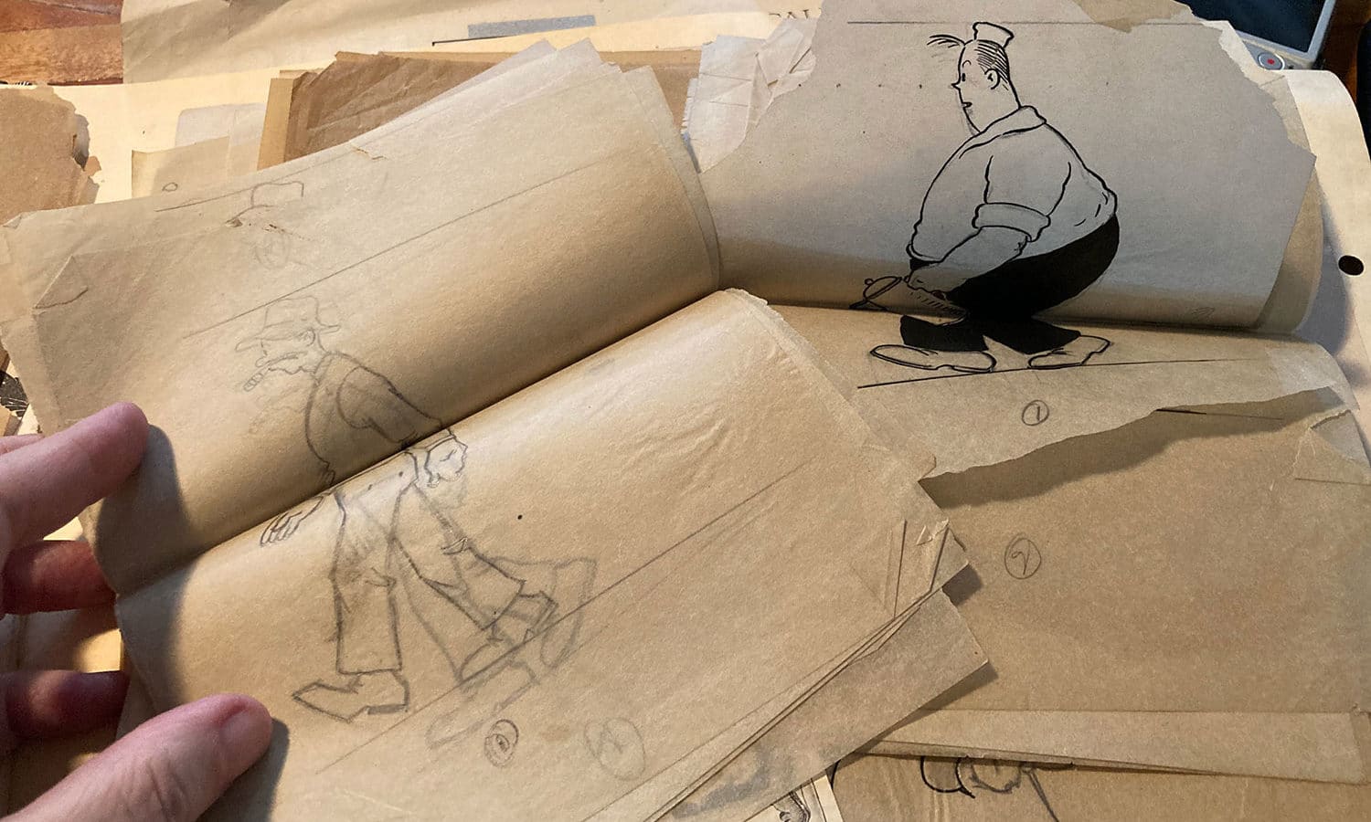 Stacks of papers featuring pencil-drawn walk cycles of two male characters