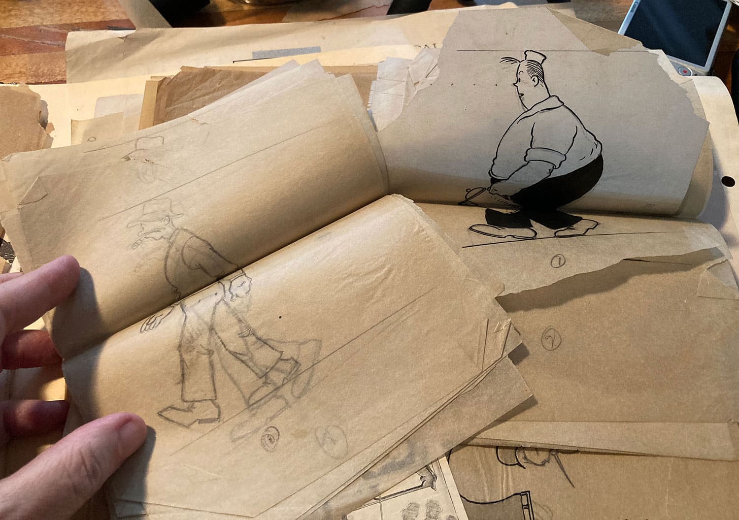 Stacks of papers featuring pencil-drawn walk cycles of two male characters