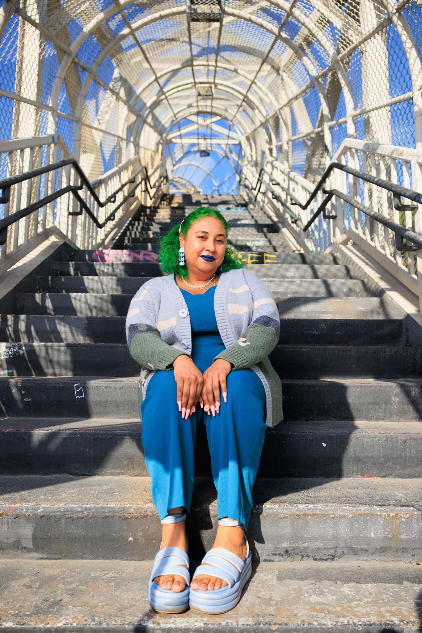 Jazmín Urrea smiles, posing seated on stairwell