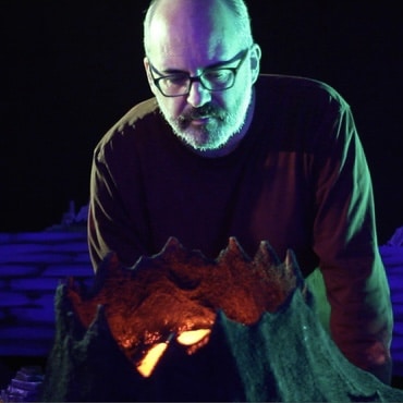 Eric Adkins looks over shining volcano model