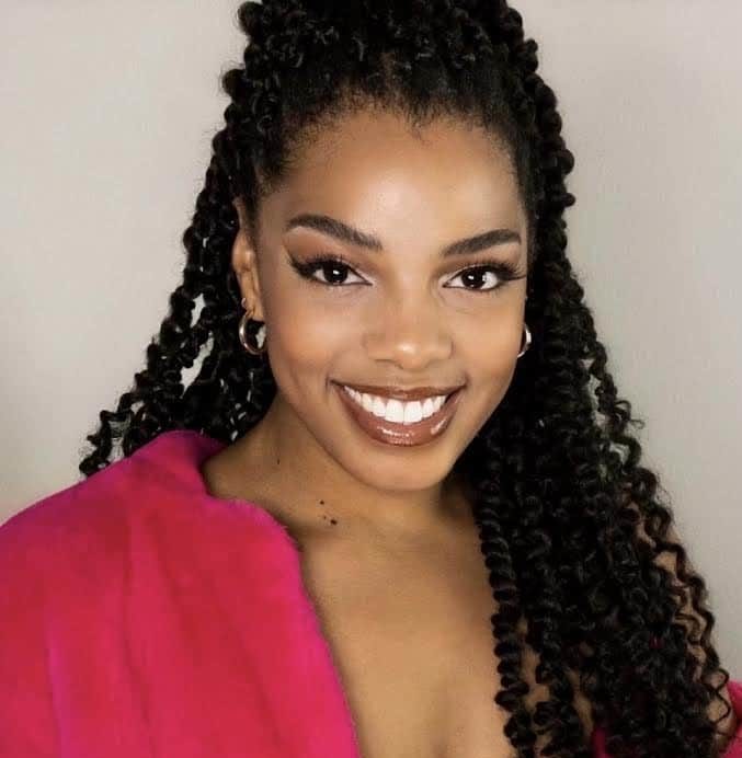 Jasmine Sugar smiling and wearing a fuschia dress and sweater